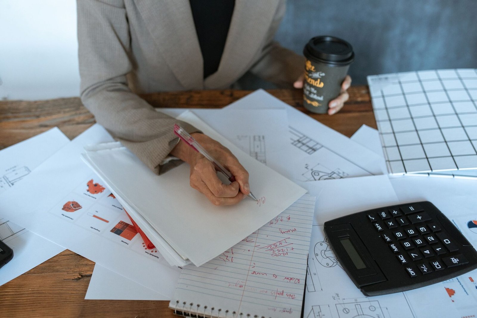 Papeles, cuadernos y una calculadora sobre un escritorio